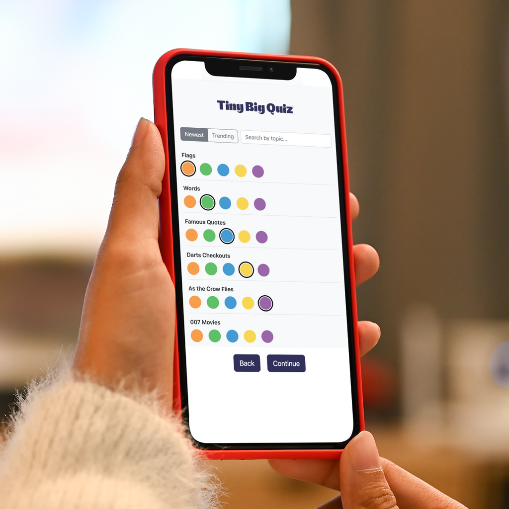 Person holding a smartphone with an app interface displayed, blurred indoor background
